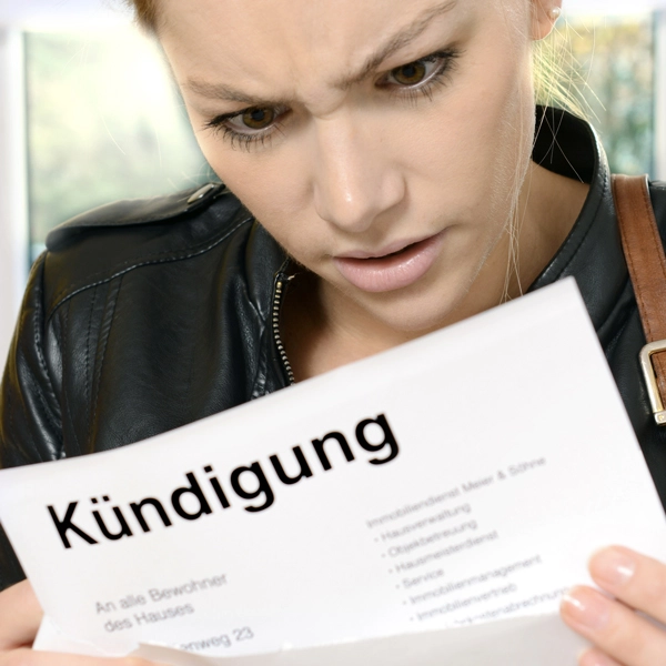 Das Bild zeigt eine Frau, die eine Kündigung in der Hand hält